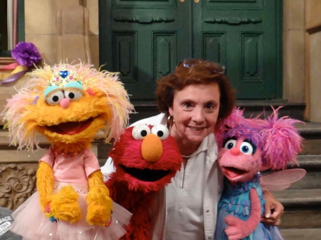 Emily Perl Kingsley and three sesam street puppets